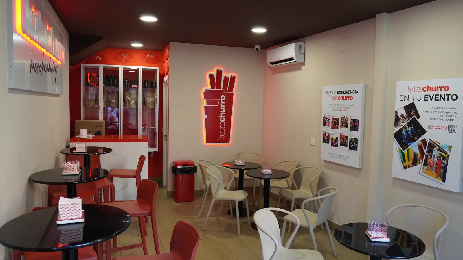 Sala del local de Kukuchurro en la Plaza del Salvador, con mesas redondas y sillas