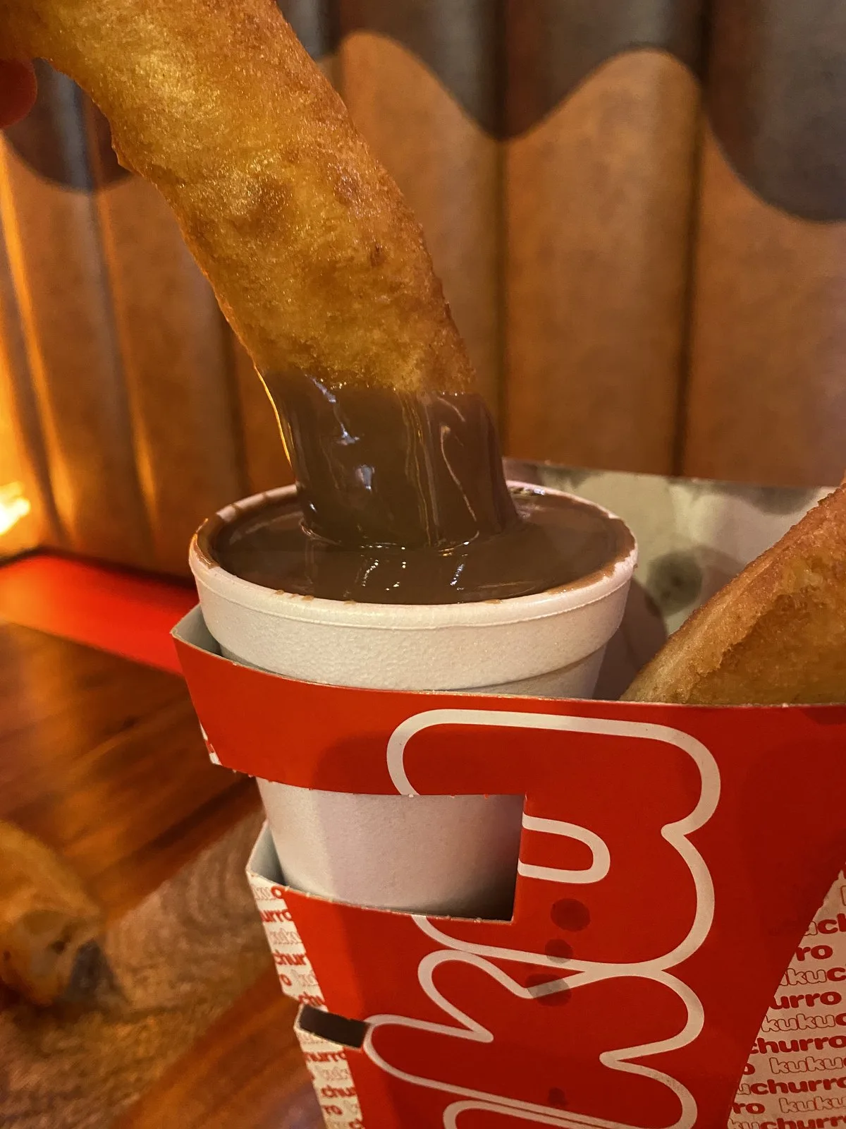 Churro dipped in hot chocolate at Kukuchurro Regina