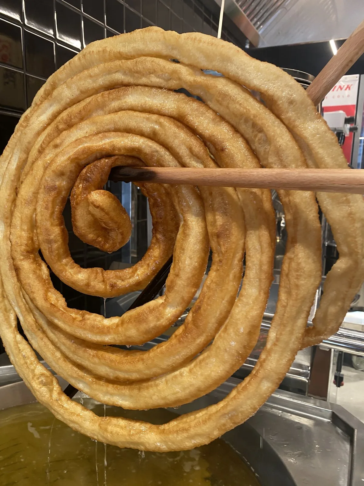 A fresh churro wheel in the fryer at Kukuchurro Catedral